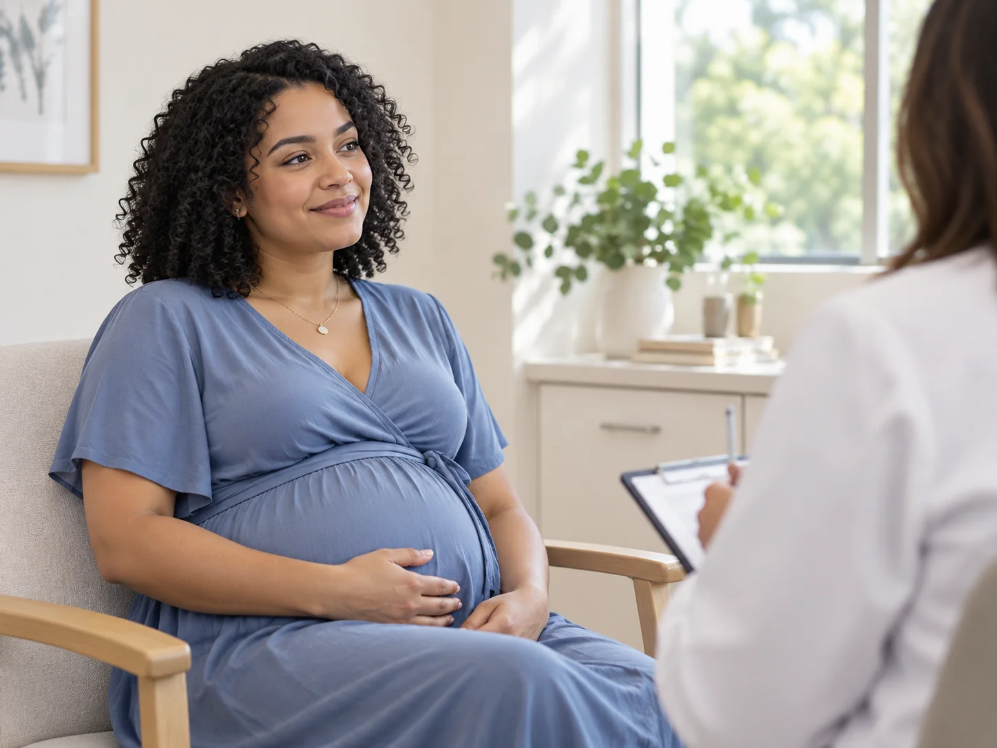 Paciente embarazada de cabello rizado conversa con un profesional de salud durante una consulta prenatal